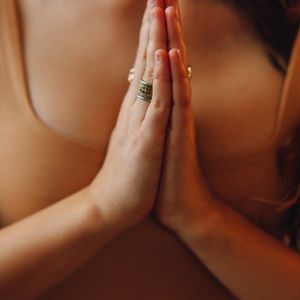 Woman's hands in a meditative gesture during practice.